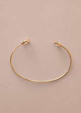 Gold bracelet on a beige background