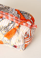 Colorful fabric pouch with tassels on a light background