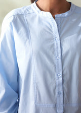 Light blue shirt worn by a person with a neutral background