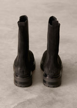 Pair of black boots on a gray concrete surface