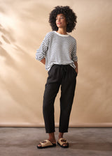 Women wearing a striped jumper with black tapered linen trousers