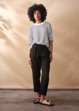 Women wearing a striped jumper with black tapered linen trousers