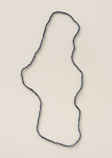 Long necklace with blue beads on a beige background