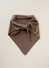 A brown knit triangle scarf with a tied bow, laid flat on a light beige background.