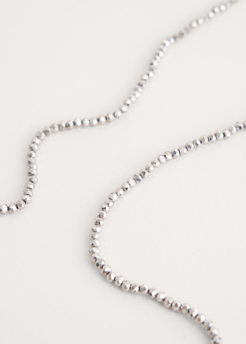 A long beaded necklace comprised of silver crystals
