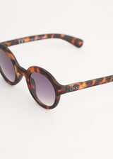 Oversized circular sunglasses with tortoiseshell pattern and blue lenses