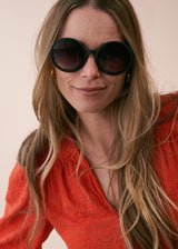 A model wearing a pair of oversized black circular sunglasses