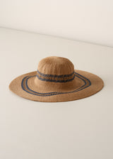 Large straw sunhat with black stripe pattern on a beige background