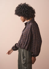 Person wearing a leopard print bubble hem shirt against a beige background