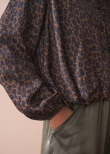 Close-up of a leopard print bubble hem shirt with a plain background