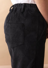 Black corduroy trousers with a beige background