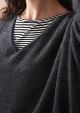 Person wearing a dark gray sweater over a striped shirt