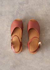 Pair of red sandals on a gray surface