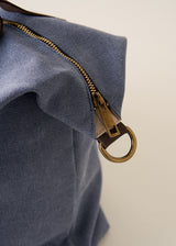 Blue bag with brown leather handles on a beige background