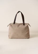 Beige tote bag with brown leather straps on a light beige background