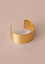 Gold bracelet on a beige background