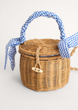 A round wicker basket with a blue gingham handle