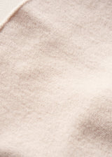 A close-up texture shot of a soft, fuzzy fabric in a light beige or cream color.