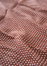 Close-up of brown fabric with white geometric pattern