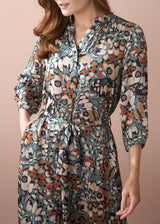 woman wearing abstract print satin midi dress with detachable belt, with her hand in the pocket