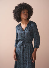 Woman wearing a patterned dress against a beige background