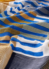 Folded striped towel with blue, white, and beige colors on a light background
