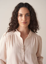 Woman wearing blush pink pinstripe blouse with puff sleeves
