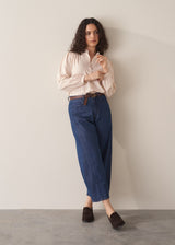Woman wearing blush pink pinstripe blouse with puff sleeves