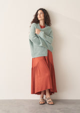 Woman wearing terracotta satin sleeveless midi dress