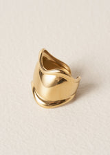 Gold chunky wave ring on a light beige background