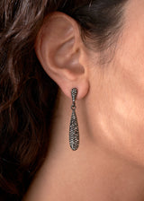 Close up of woman wearing sparkly silver crystal adorned tear drop earrings