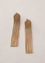 Gold chain tassel earrings on beige background