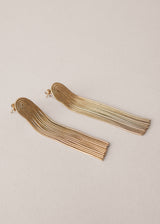 Gold chain tassel earrings on beige background