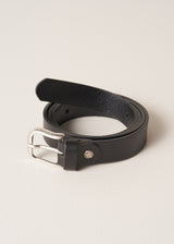 Black real leather belt with a brushed silver buckle, on a beige background