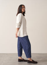Woman wearing an off-white oversized blazer over with blue denim jeans