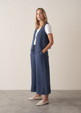 Woman wearing a navy blue linen waistcoat with wide leg linen trousers