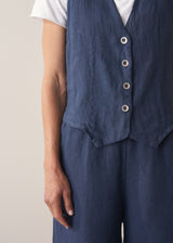 Woman wearing a navy blue linen waistcoat with wide leg linen trousers