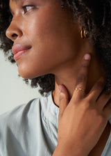 Woman wearing open centre gold bubble ring with blue blouse