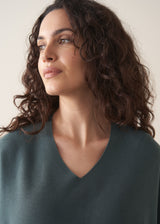 Woman wearing a teal v-neck sweater