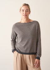 Woman wearing beige and grey stripe sweater with button back and beige cropped trousers