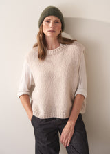 Women wearing a super soft, alpaca wool blend beanie in khaki, styled with an oatmeal sweater and dark jeans