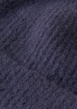 Close up of knit detail on an ultra soft, alpaca wool blend beanie hat in navy