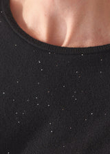 Close up of neckline on a black sweater with subtle sequin detail.