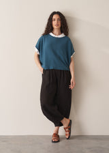 Woman wearing bright blue sleeveless knitted sweater