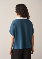 Woman wearing bright blue sleeveless knitted sweater