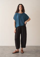 Woman wearing bright blue sleeveless knitted sweater