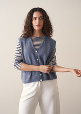 Model wearing blue and white stripe knit sweater with pale blue waistcoat and white barrel leg jeans