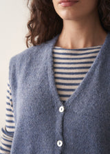 Close up of model wearing blue and white stripe knit sweater with pale blue waistcoat