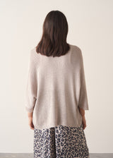 Woman wearing greige open knit relaxed cardigan and leopard print torusers