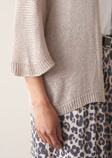 Woman wearing greige open knit relaxed cardigan and leopard print torusers